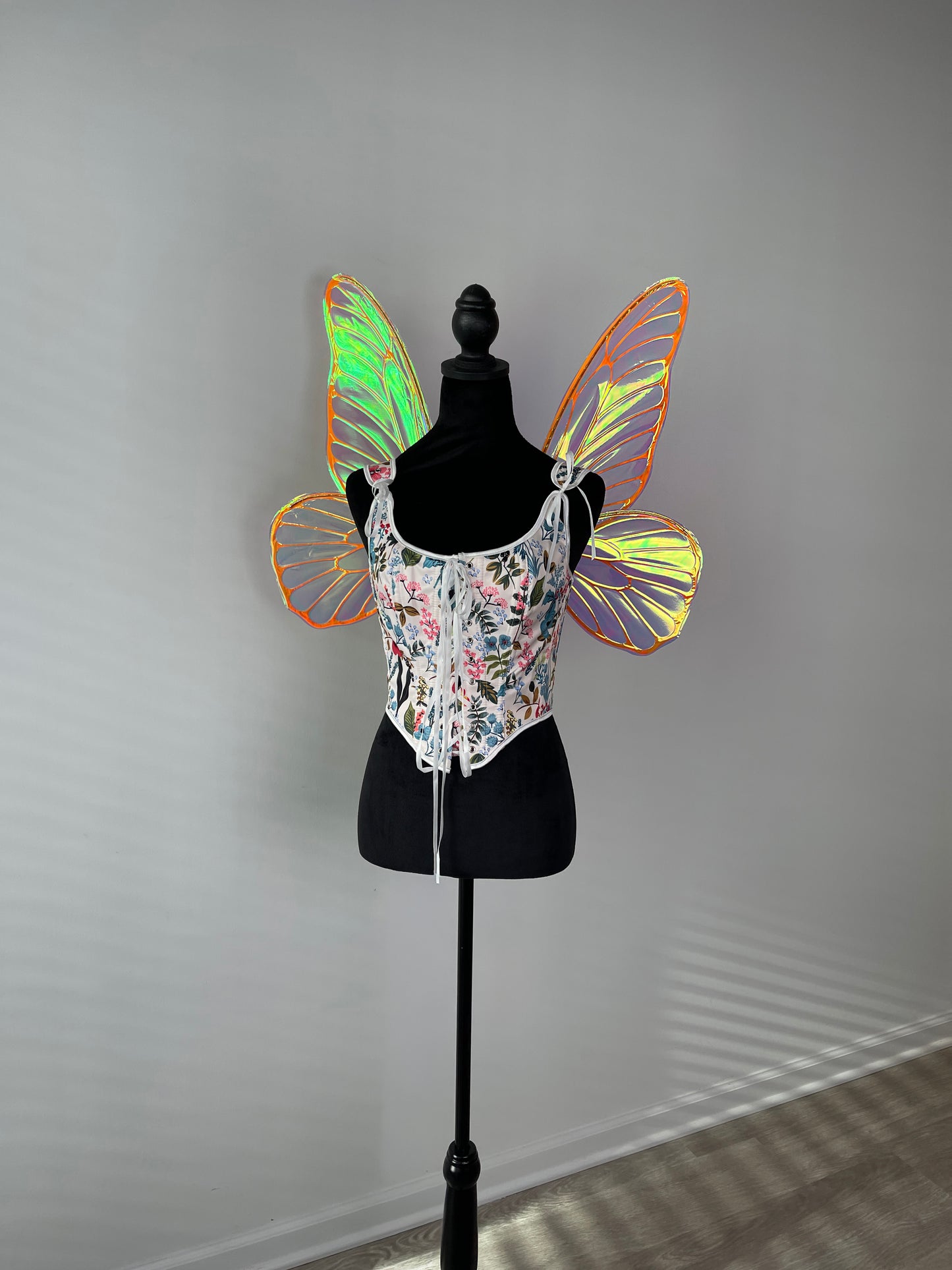 Butterfly wings on a mannequin against a gray background