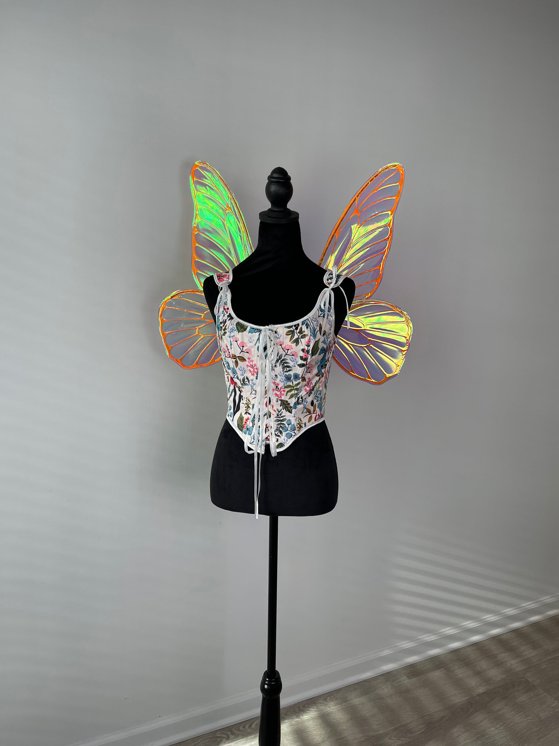 Butterfly wings on a mannequin against a gray background