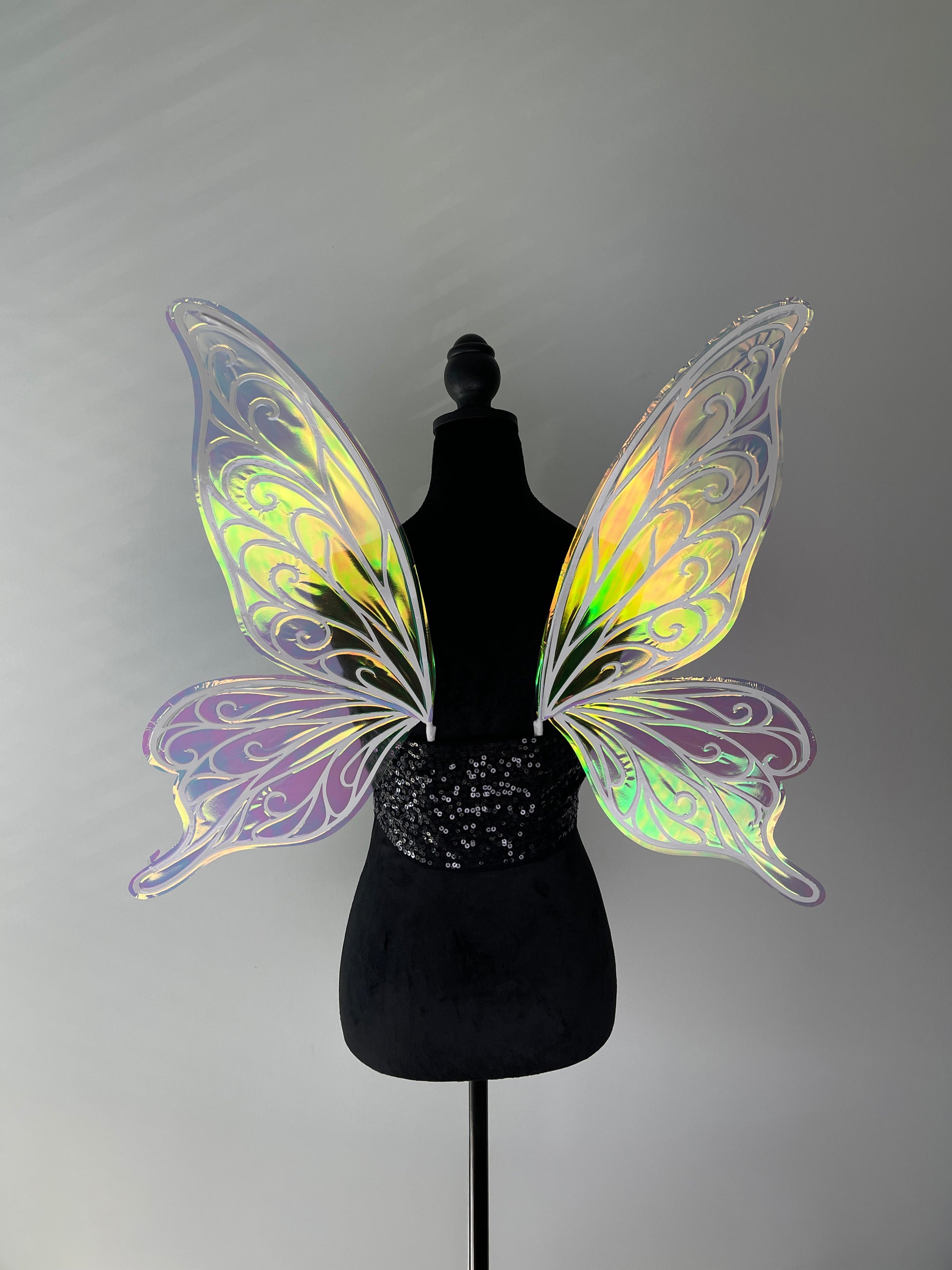 Iridescent butterfly wings on a mannequin against a gray background
