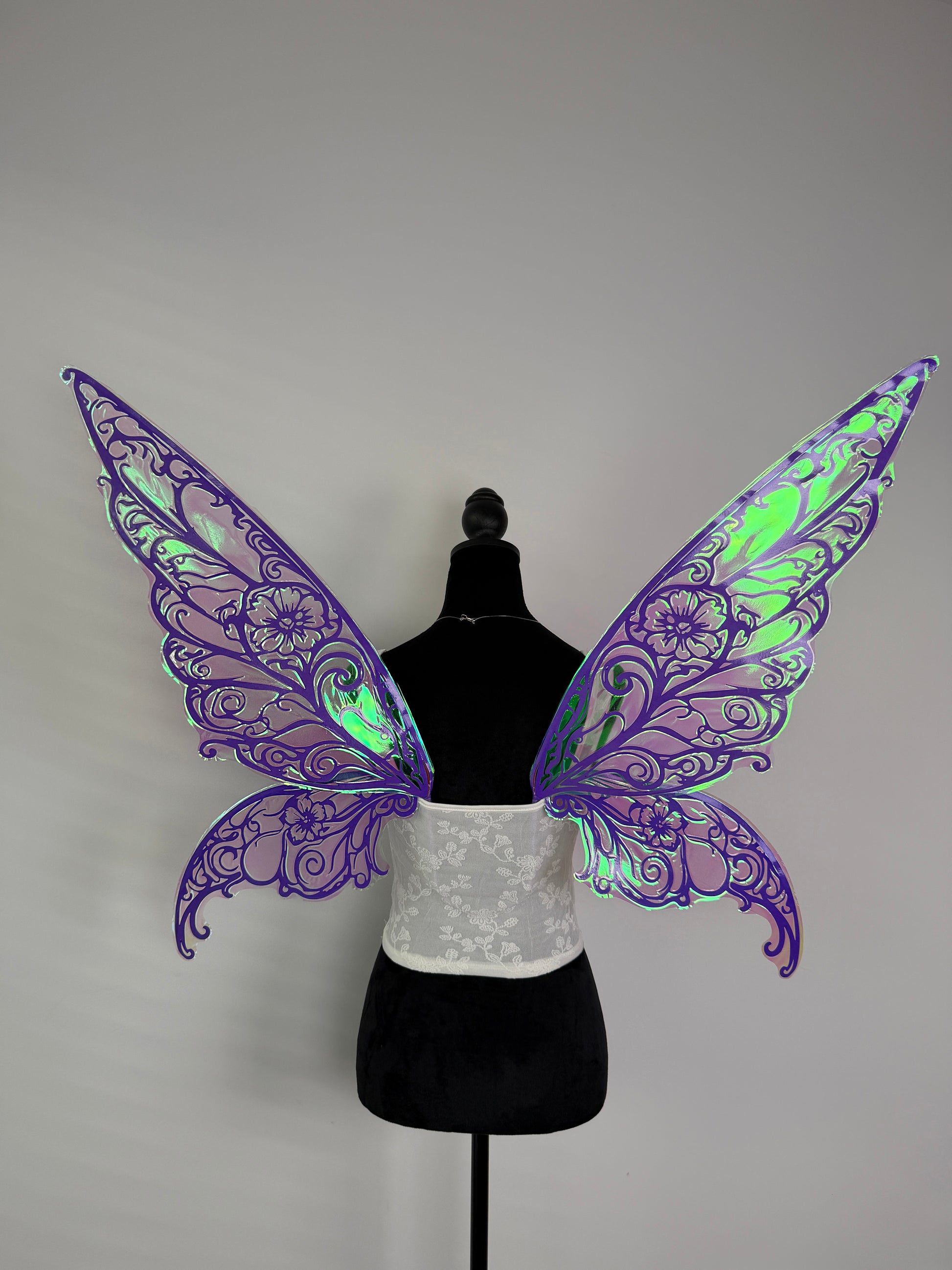 Purple butterfly wings on a mannequin against a gray background