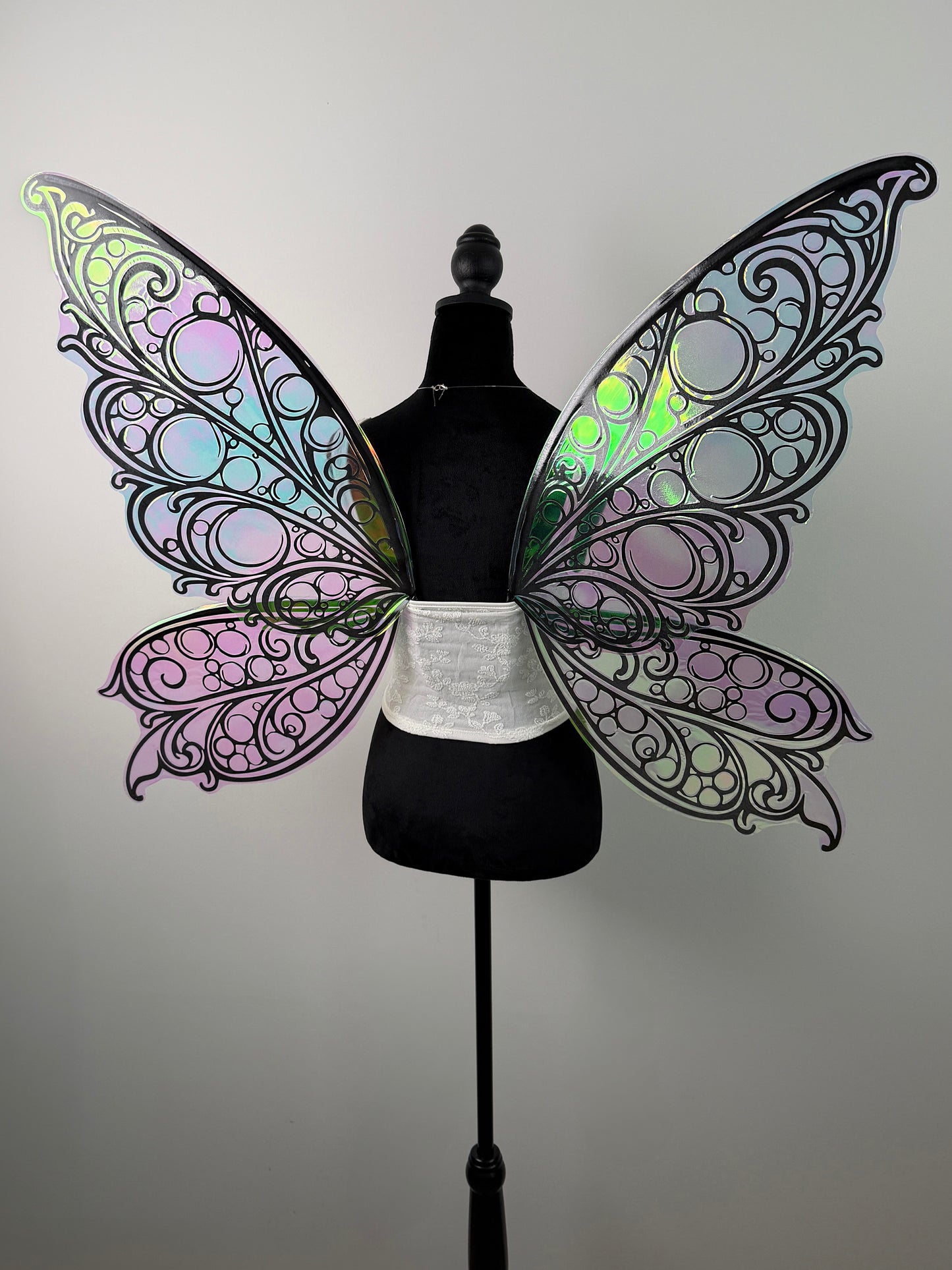 Butterfly wings on a mannequin against a plain background
