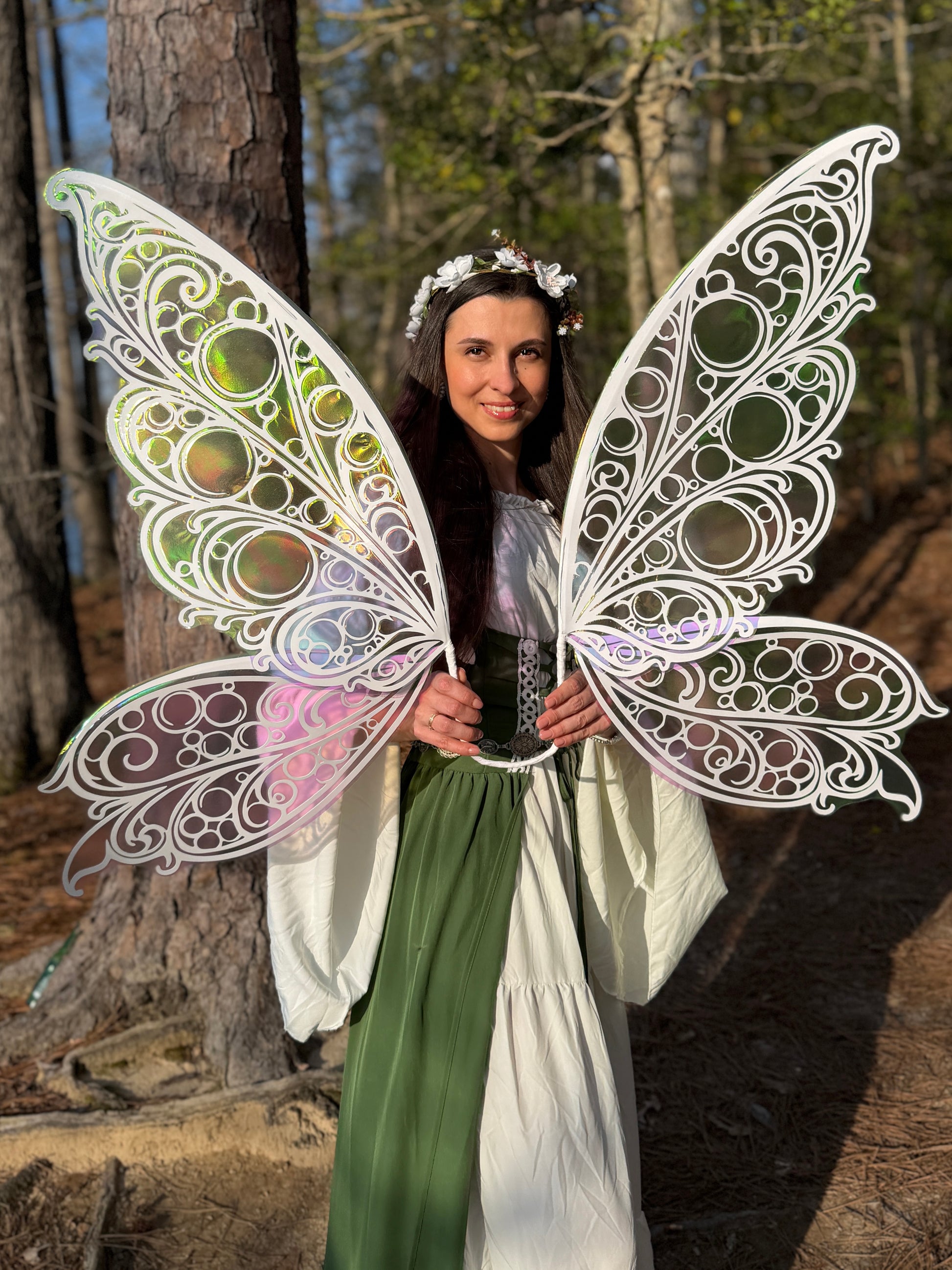 Person wearing large, decorative butterfly wings in a forest setting