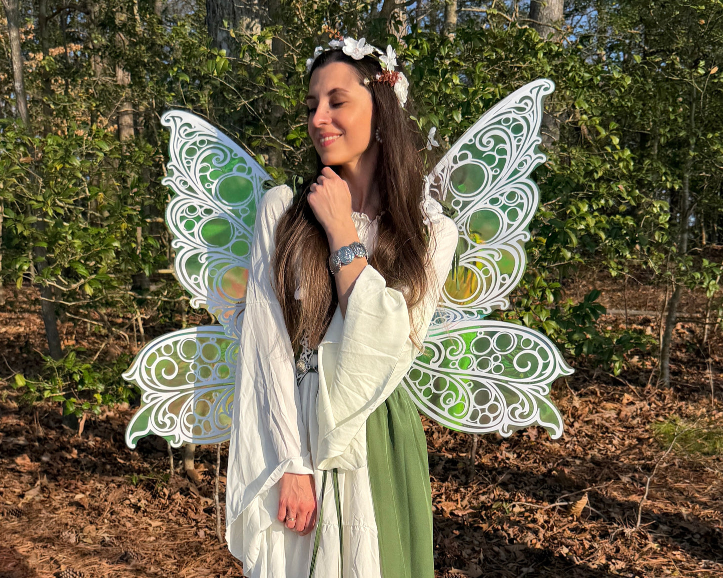 Person in a fairy costume with large butterfly wings standing in a forest setting.