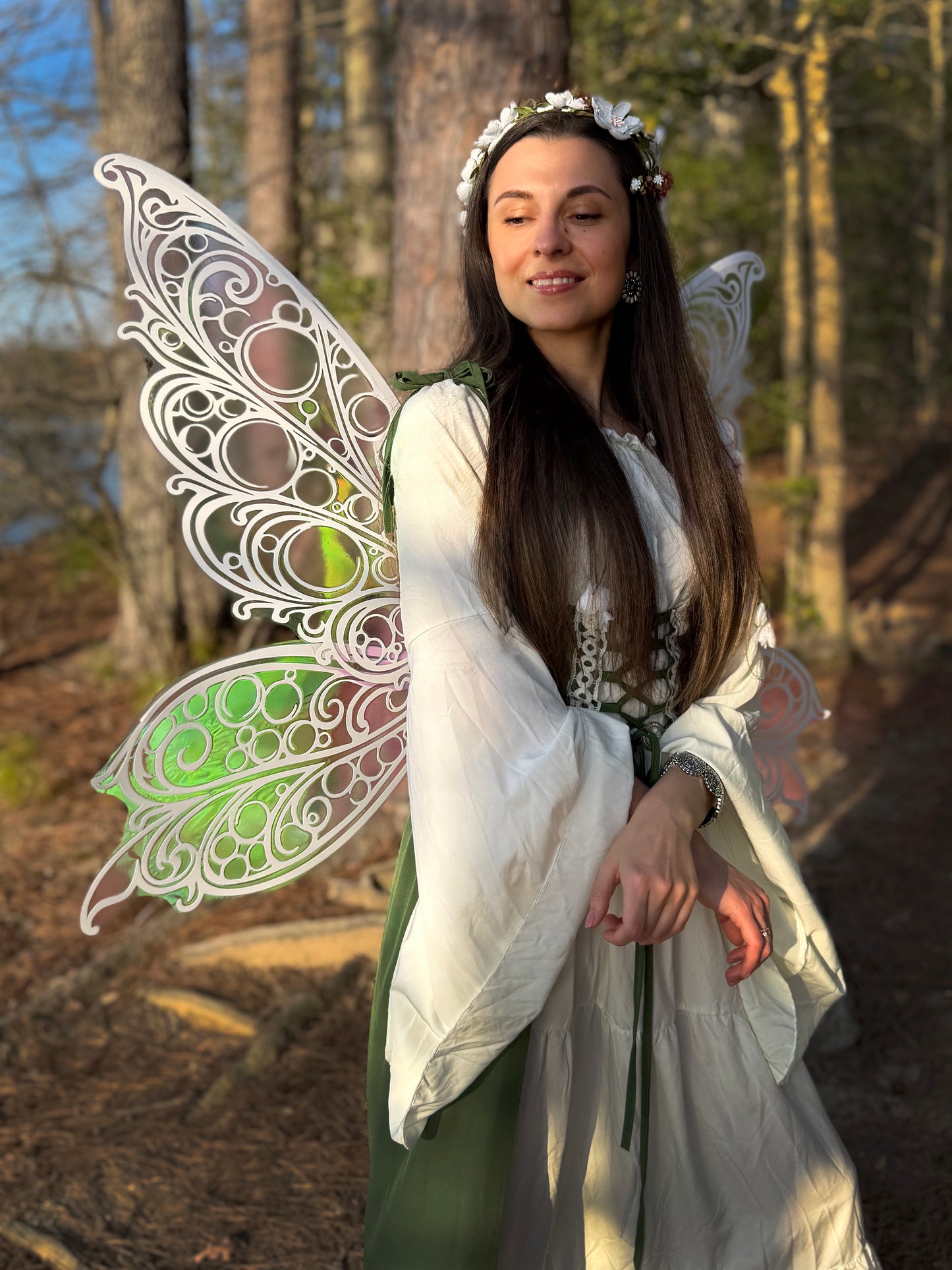 Woman in fairy costume with large butterfly wings in a forest setting
