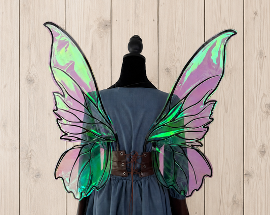 Iridescent fairy wings with luminous purple and green color shifts displayed on a dress form