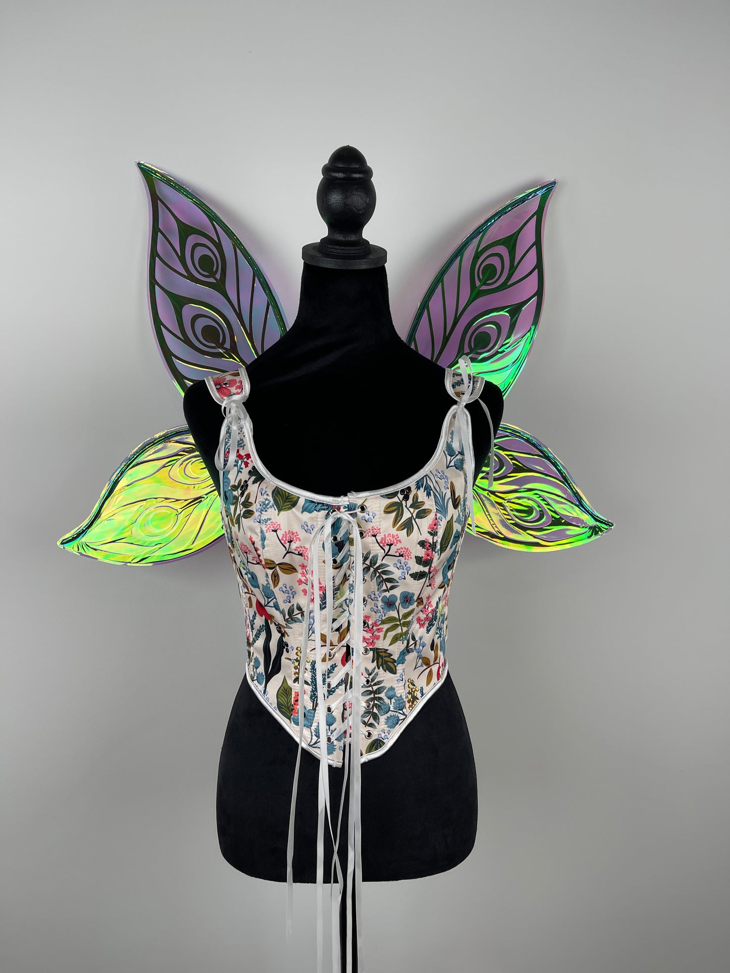 Decorative butterfly wings on a mannequin against a gray background